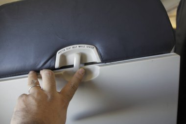 Bir insanın eli uçakta bir düğmeye basıyor..