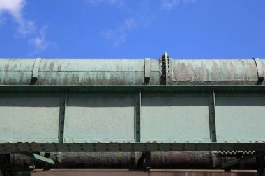 Parlak mavi gökyüzüne karşı paslı endüstriyel metal yapı