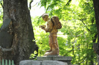 Kitap okuyan çocuğun bronz heykeli