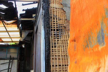 Yanmış ahşap duvar, yanmış lath ve yanmış kalıntıları gösteriyor.