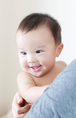 Annenin ellerinde mutlu Japon çocuk, ellerinde küçük oğlunu tutan kadın, yakın plan. 