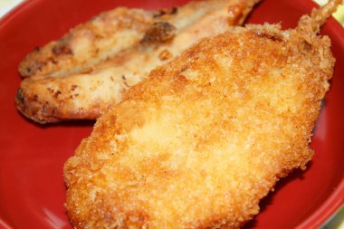 Crispy fried fish on red plate