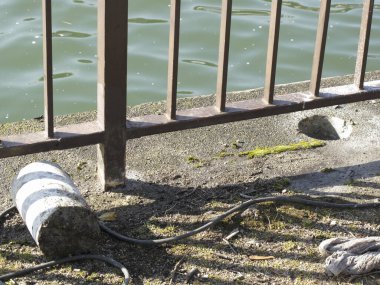 Arka plandaki nehir kenarındaki eski metal çitleri kapatın.