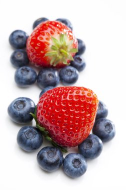 Beyaza izole edilmiş taze çilek ve yaban mersini. 