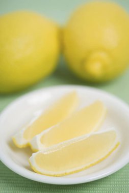 Bir limonu kapat ve beyaz bir tabakta dilimle.