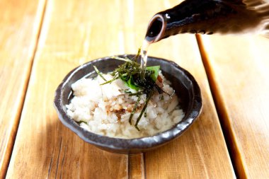 Pirincin üzerine su yosunu garnitürüyle çorba dök.