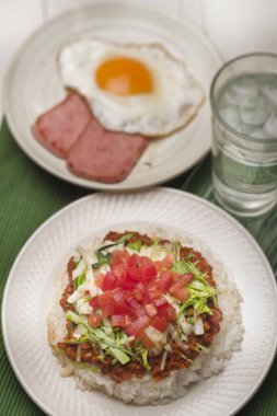 Kahvaltıda yumurta, pilav, sebze ve kızarmış tavuk.