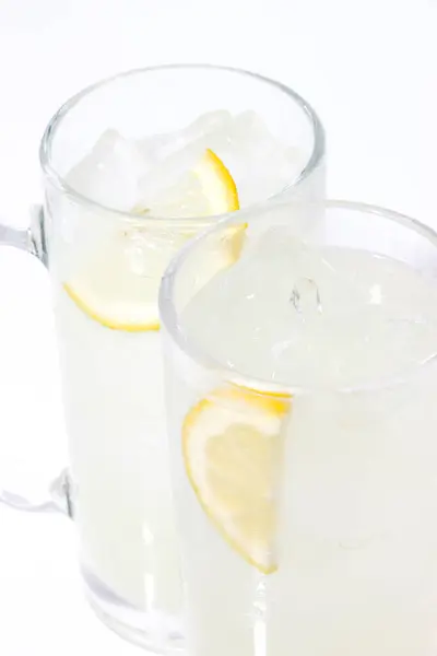 白い背景に隔離されたガラス マグカップの新鮮なレモンスライス — ストック写真