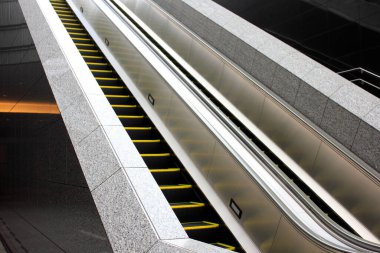 Arka plandaki metro istasyonunda yürüyen merdiven.