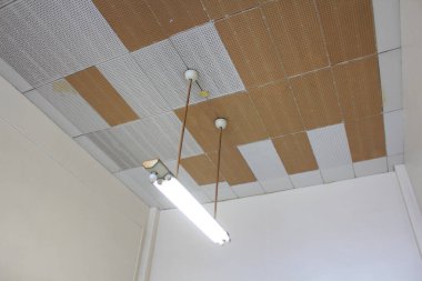 Kapalı alandaki tavandan sarkan floresan lamba armatürü.