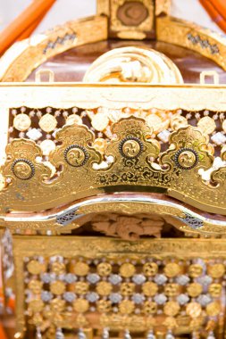 Karmaşık oymalar ve dekoratif desenler içeren süslü altın bir yapı.