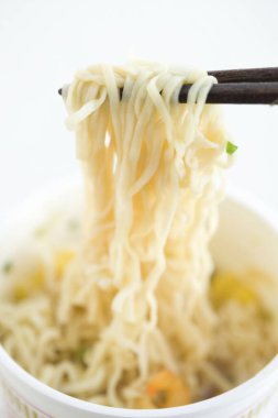 Arka planda yemek çubuğu olan bir kasede erişte.