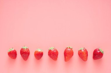 Pembe üzerine izole edilmiş taze çilekler.