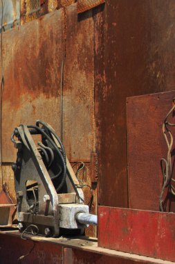 Paslanmış endüstriyel makineler büyük metal panellerde dinleniyor.