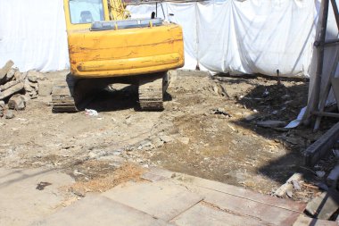 İnşaat alanında toprak ve enkazla birlikte sarı kazıcı.