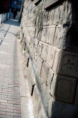 Güneş ışığı eski taş duvar kaldırımı boyunca gölgeler bırakıyor.