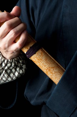 Sırtında katana olan geleneksel giysili genç Asyalı adam. 