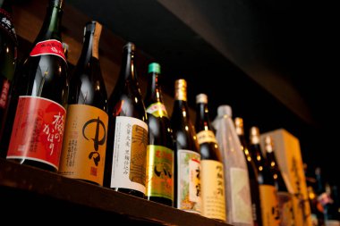 Çeşitli sake şişeleri gösteriliyor.