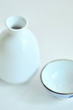 Beyaz seramik sake şişesi ve bardak.