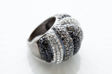 Beyaz zemin üzerinde değerli taşlar olan lüks yüzüğün yakın plan görüntüsü                    