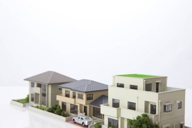 Beyaz arka plandaki küçük ev modelleri, ipotek kavramı