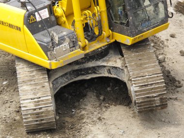 İnşaat alanındaki bir yolda kazıcı. 