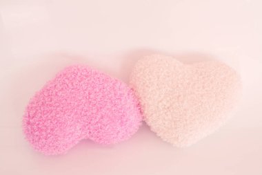 açık arkaplanda kalp şeklinde pembe ve sarı banyo süngerleri.