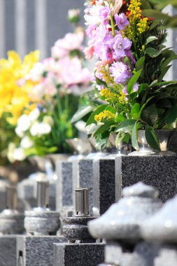 Parkta çiçekli eski taş mezarlık manzarası