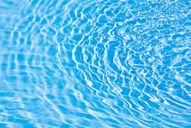 Mavi yüzeyi ve dalgaları olan bir havuz.