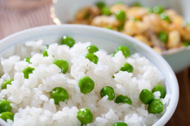 Lezzetli pirinç ve bezelyeli yeşil kase, yakın plan.