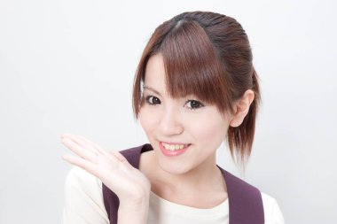 Beyaz arka planda poz veren güzel Japon kadın resepsiyonistin stüdyo portresi