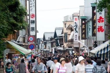İnsanlar alışveriş alanında sokakta yürüyorlar.