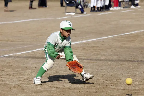 Japanese boy playing baseball on field