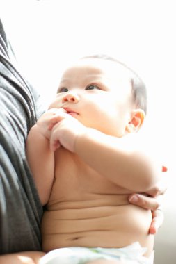 Annenin ellerinde mutlu Japon çocuk, ellerinde küçük oğlunu tutan kadın, yakın plan. 