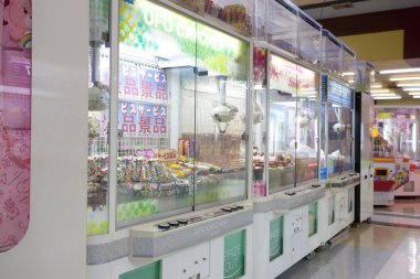 İçinde renkli pençe makineleri bulunan parlak atari salonu.