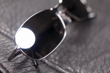 Siyah deri arka planda güneş gözlüğünü kapat