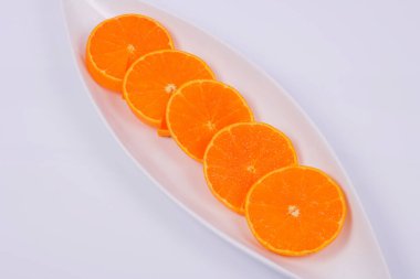 Beyaz arkaplanda izole edilmiş dilimlenmiş portakal tabakası 