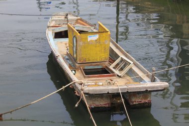 Sakin sularda yüzen terk edilmiş bir tekne.