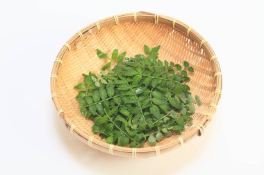 Tahta sepetteki taze otlar beyaz arka planda izole edilmiş.
