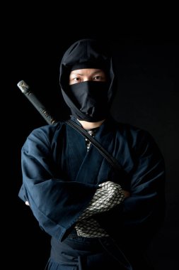 Sırtında katana olan geleneksel giysili genç Asyalı adam. 