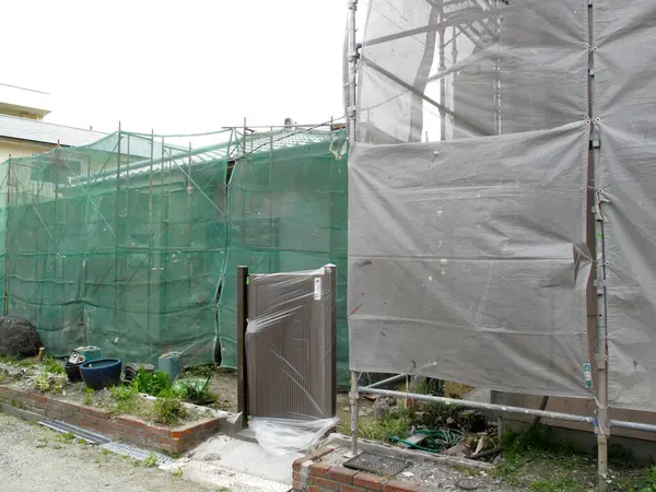 İnşaat alanı yeşil ağ ve gri muşambalarla kaplı