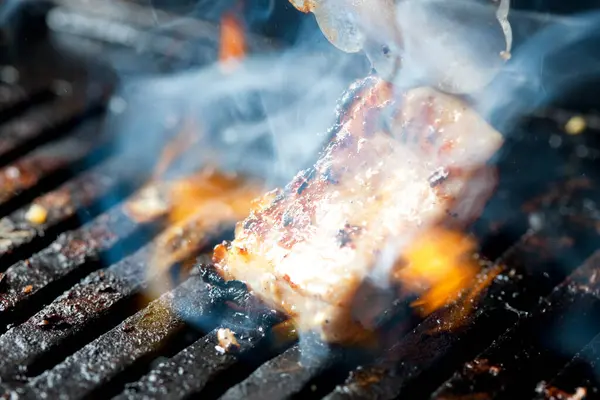 金属钳子和烤肉上美味肉的特写镜头 — 图库照片
