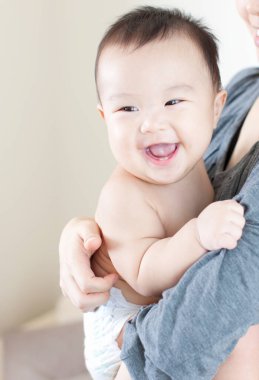 Annenin ellerinde mutlu Japon çocuk, ellerinde küçük oğlunu tutan kadın, yakın plan. 