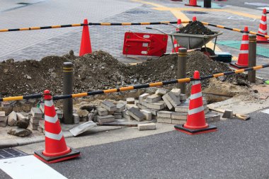 Turuncu trafik konileri toprak yığınlarıyla çevrili yol şantiyesi