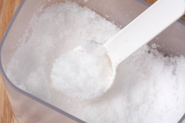 Beyaz kaşıkta beyaz masada şeker, yaklaş.