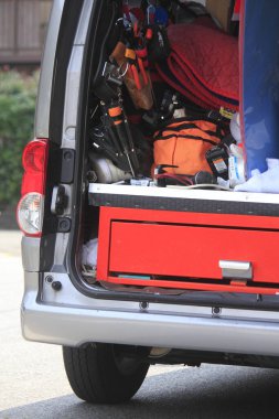 Arka planda bir sürü alet edevat olan bir araba.