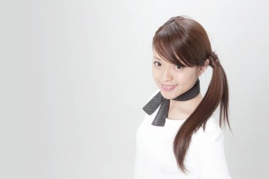 Beyaz arka planda poz veren genç ve güzel Japon iş kadınının stüdyo portresi