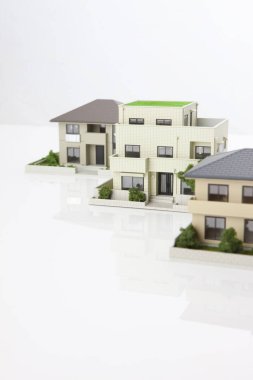Beyaz arka plandaki küçük ev modelleri, ipotek kavramı