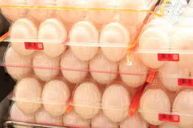 Süpermarkette içi taze yumurta dolu plastik kapların yakın plan görüntüsü.                   