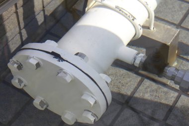 Beton yüzeyde uzanan büyük endüstriyel boru hattı segmenti